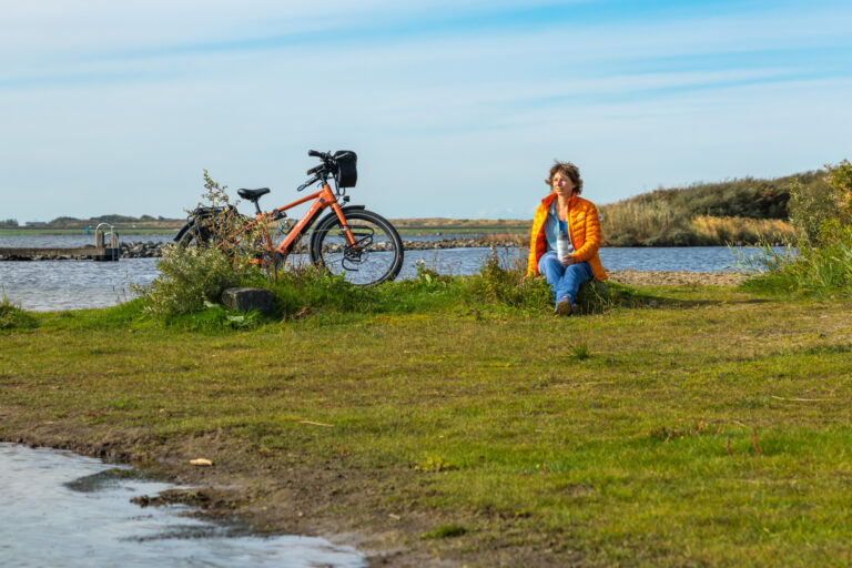 Fietser kijkt uit over het Grevelingenmeer (Kabbelaarsbank)